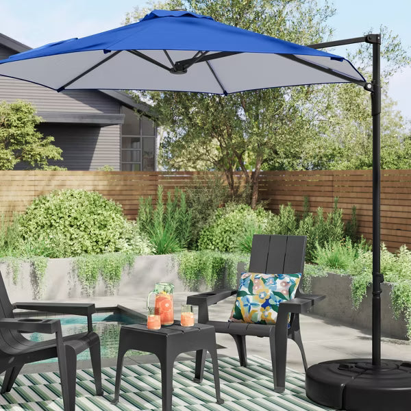 Outdoor patio set with blue umbrella, chairs, and table in a garden setting.